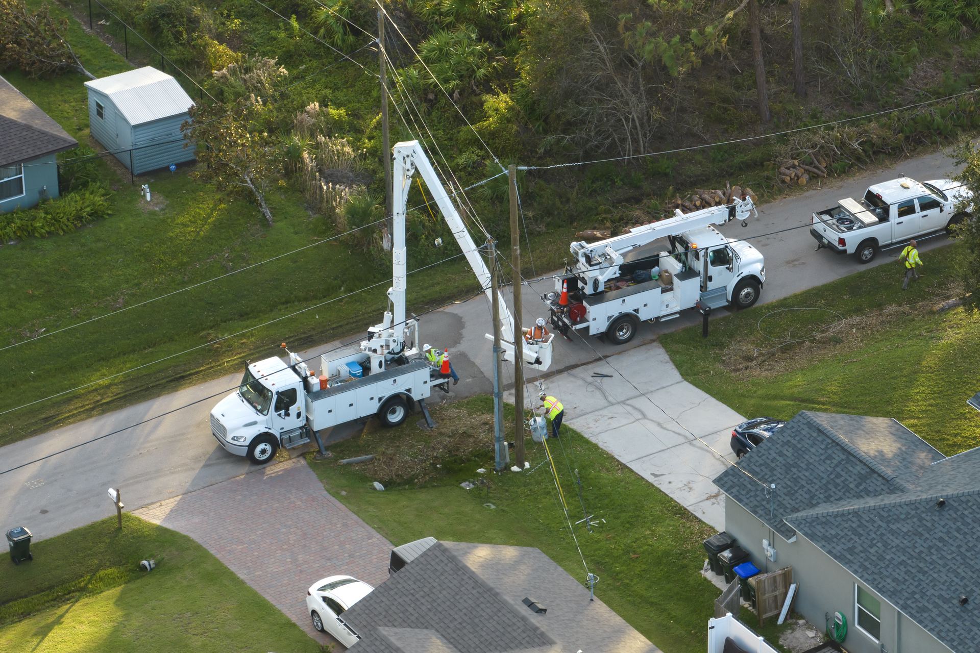 Utility crews restoring overhead lines from bucket trucks
